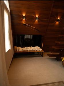 a room with wooden ceilings and a table with towels at Chalé Maloca in Cariry +10 photos