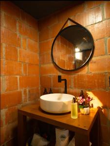 a bathroom with a white sink and a mirror at Chalé Maloca in Cariry