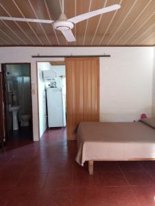 a bedroom with a bed and a refrigerator at Hospedaje Silvia in Salto