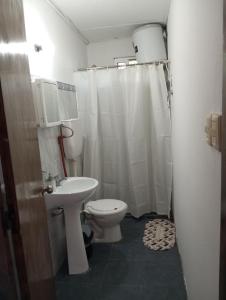 a white bathroom with a toilet and a sink at Hospedaje Silvia in Salto +11 photos