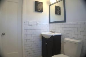 a bathroom with a sink and a toilet and a mirror at Brand new 3 bedroom apt close to all in West Babylon +23 photos