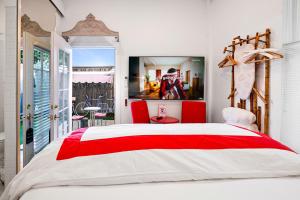 a bedroom with a red and white bed and a balcony at metro hotel and Cafe in Petaluma +42 photos