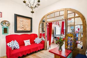 a red couch in a living room with a chandelier at metro hotel and Cafe in Petaluma