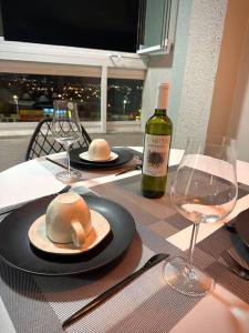 a table with a bottle of wine and two glasses at Apartamento completo, próx às praias in Ôlho dʼÁgua