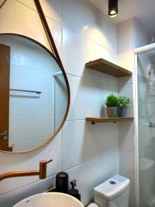 a bathroom with a mirror and a sink and a toilet at Apartamento completo, próx às praias in Ôlho dʼÁgua