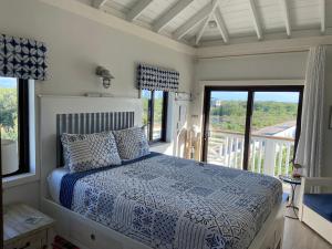 a bedroom with a bed with a blue and white comforter at Casa Cava Bed & Breakfast in San Pedro