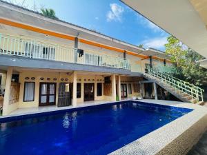 a large swimming pool in front of a house at Mawar Bungalow in Gili Trawangan