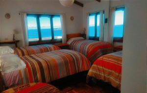 una camera con tre letti e vista sull'oceano di Hostal Inti Wayra a Comunidad Yumani