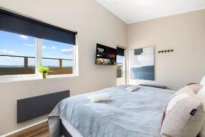 a bedroom with a large bed and a large window at Þingvallavatn Hot Tub Sauna 2024 Built Cabin in Veiðilundur