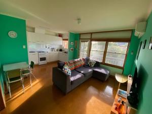 una sala de estar con un sofá y una mesa en Cute Retro Gem, en Geelong