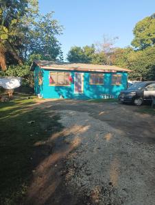 a blue house with a car parked in front of it at Kapeta Cabin in Nuku‘alofa