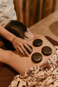 a woman laying on her stomach with spa stones at ARTOTEL Haniman Ubud in Ubud