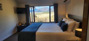 Un dormitorio con una cama con vistas a la montaña. en The Bealey Hotel, en Arthur's Pass
