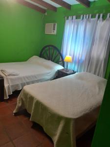 2 camas en una habitación verde con ventana en El Guerrero Club de Campo, en Colonia Benítez 9 fotos más