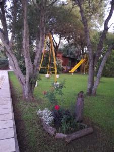 un parque con un parque infantil con un tobogán amarillo en El Guerrero Club de Campo, en Colonia Benítez