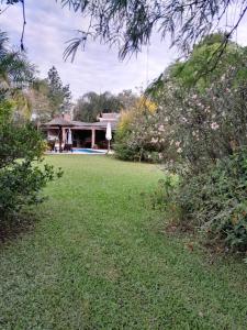 un patio con una casa al fondo en El Guerrero Club de Campo, en Colonia Benítez