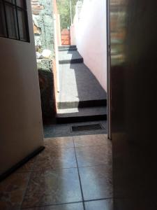 an open door to a hallway with a stairway at Departamento la Quebrada 1 in Río Ceballos