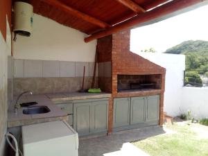 an outdoor kitchen with a sink and a brick oven at Departamento la Quebrada 1 in Río Ceballos