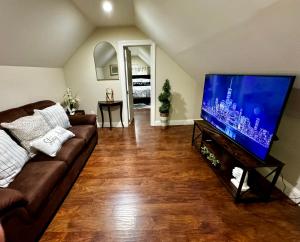 ein Wohnzimmer mit Sofa und einem großen Flachbildfernseher in der Unterkunft Private Cozy Apartment - Only 5 min Away from Newark Airport and 30 min to NYC in Elizabeth