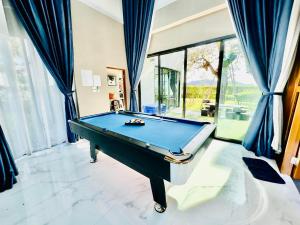 穆克莱克Do2poolvilla Khaoyai的一张带蓝色窗帘的台球桌