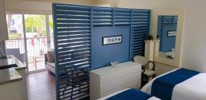 a bedroom with a blue wall with a bed and a mirror at Relax at Private beach, Pools, Acuatic Park & more in Bayahibe