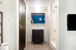 a bathroom with a sink and a tv on the wall at Apartment Sanjo in Nara