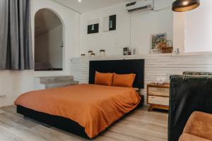 a bedroom with a bed with an orange bedspread at Nhà Bơ Homestay in Phan Rang
