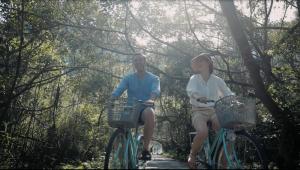 Un hombre y una niña andan en bicicleta por un sendero en Cat Ba Cruise, en Cat Ba