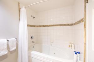 a white bathroom with a tub and a shower at Powderhorn at Whistler Blackcomb in Whistler +14 photos