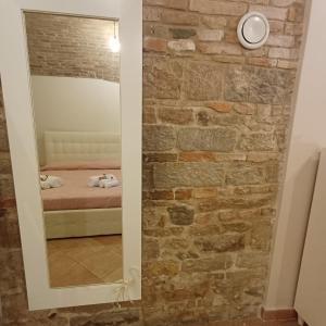 a mirror in a room with a brick wall at Loft Gioia in Perugia +68 photos
