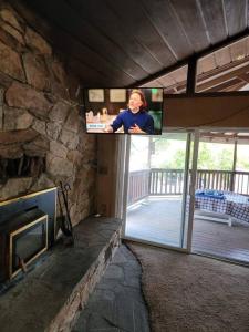 a woman on a television in a room with a fireplace at House on Avenue of the Giants, Miranda, California in Miranda