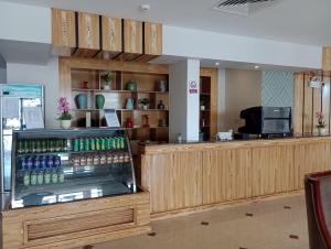a restaurant with a counter with a drink cooler at Taleen Serviced Apartments Al-Ahsa- تالين الاحساء للشقق المخدومة in Ruqaiqah