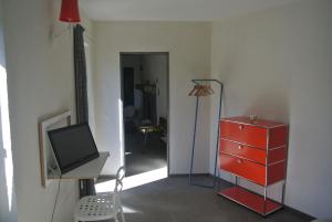 a living room with a red dresser and a tv at A Cà balade in Design in Miglieglia