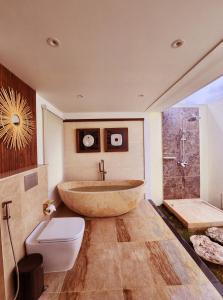 a bathroom with a large tub and a toilet at KANDORA Luxury villas in Maujawa