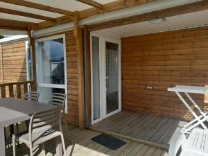 un patio con tavolo e sedie su un ponte di mobil-home philvar a Douarnenez