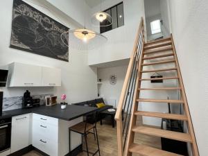 a kitchen and a staircase in a small apartment at Appartement avec du cachet in Mont-sous-Vaudrey