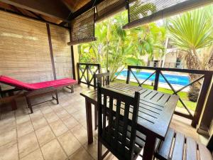 a porch with a table and chairs and a view of the ocean at Résidence Kambana in Nosy Be