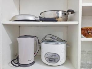 twee apparaten op een plank in een keuken bij Ann's Guesthouse in Butuan +18 foto's