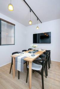 a dining room with a wooden table and black chairs at T-home彩 in Tokyo