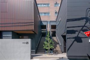 a building with stairs and a tree in front of it at T-home彩 in Tokyo