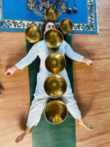 a woman laying on the floor with a group of gold spheres at The Begnas sound healing center in Deorāli