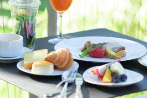 a table with two plates of food and a glass of wine at Hotel The Day Osaka in Osaka