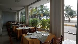 a row of tables in a restaurant with a large window at Costa Paraiso in Atacames