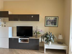 a living room with a flat screen tv on a cabinet at Suite Laghetto EUR in Rome +14 photos
