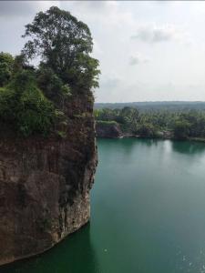 a large body of water next to a large cliff at River Heart Homestay in Aranmūla