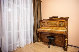 an old piano with a stool next to a window at Apartment On Khreshchatyk 21 in Kyiv