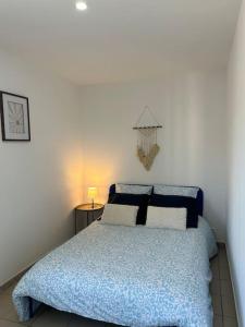 una camera da letto con un letto con un piumone blu di L'Adrien Hébrard parking facile a Grisolles