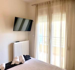 a bedroom with a bed with a television on the wall at Adeste to Ioannina Apartment in Ioannina