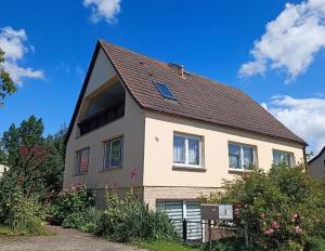 ein Haus mit einem braunen Dach und einigen Büschen in der Unterkunft Ferienappartement in Lauterbach auf Rügen! in Lauterbach