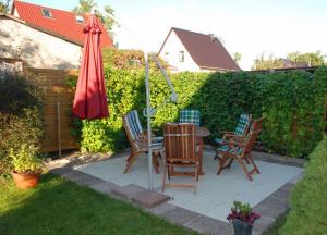 eine Terrasse mit Tisch und Stühlen und einem Sonnenschirm in der Unterkunft Ferienappartement in Lauterbach auf Rügen! in Lauterbach